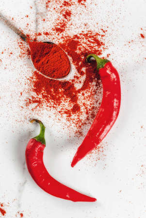 Raw fresh organic and dried ground chili pepper on white marble background top view copy spaceの写真素材
