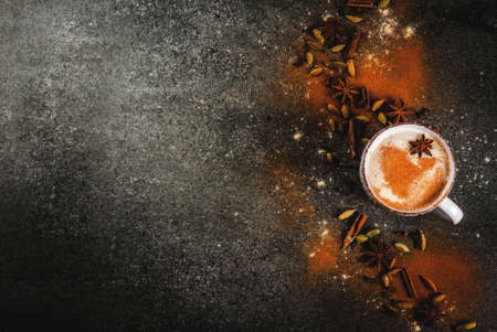 Traditional indian masala chai tea with spices - cinnamon, cardamom, anise, dark stone background. Copy space top viewの写真素材