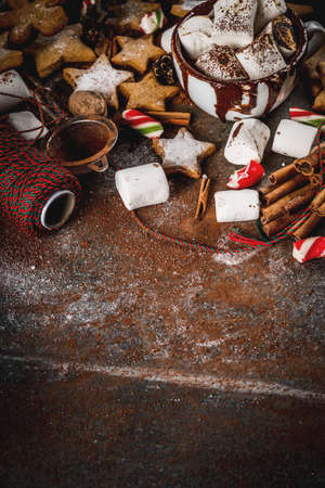 New Year, Christmas treats, sweets. Cup of hot chocolate with fried marshmallow, ginger star cookies, gingerbread men, striped candy, spices cinnamon anise, cocoa, powdered sugar.  Copy spaceの写真素材