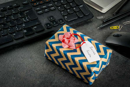 Office Christmas celebration concept, the idea of sharing gifts secret Santa. Keyboard, mouse,...