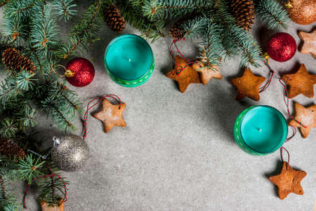 Christmas table, background for greeting card. Christmas decoration, candles, fir tree and gingerbread cookies on grey stone table. Top view, copy space.の写真素材