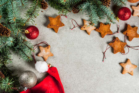 Christmas table, background for greeting card. Christmas decoration, candles, fir tree and gingerbread cookies on grey stone table. Top view, copy space.の写真素材