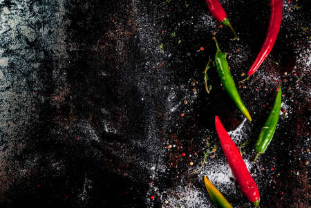 Spices for cooking. Spicy red and green chilli peppers on old metal rusty background, top view copy spaceの写真素材