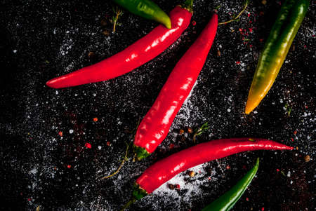 Spices for cooking. Spicy red and green chilli peppers on old metal rusty background, top view copy spaceの写真素材