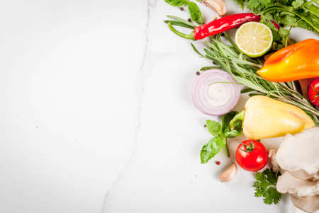 Food cooking background, white marble table. Fresh raw organic vegetables (tomatoes, peppers, mushrooms, onion), herbs, spices, lime for preparation dinner. Top view copy spaceの写真素材