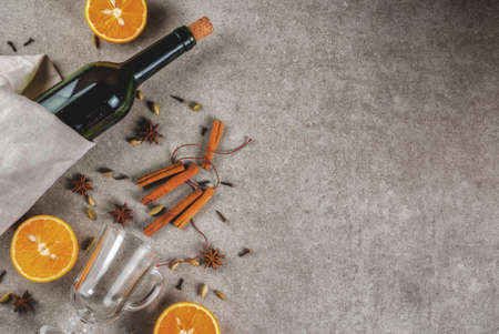  Christmas hot drinks recipes, Set of ingredients for mulled wine: wine bottle, glass cups, spices, orange. Gray stone background,Top view spaceの写真素材