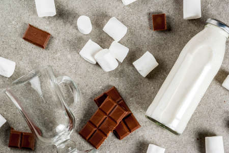 Christmas hot drinks recipes, Set of ingredients for hot chocolate: milk bottle, chocolate, marshmallow. Gray stone background, copy space top viewの写真素材