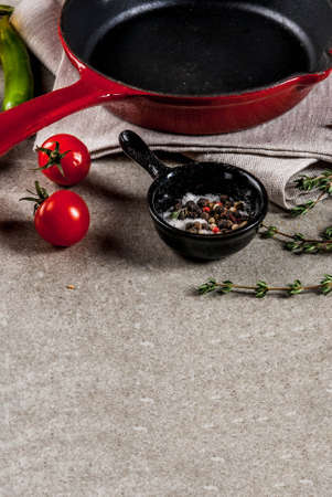 Grey stone culinary background with empty black pan and selection of spices and seasonings, copy spaceの写真素材