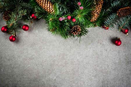 Christmas fir tree branch with pine cones and decorations on grey stone table. Top view, copy spaceの写真素材