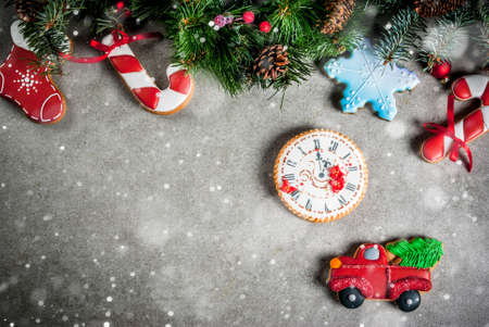 Christmas background with fir tree branch, homemade colorful gingerbread cookies, pine cones and decorations on grey stone table. Top view, copy spaceの写真素材