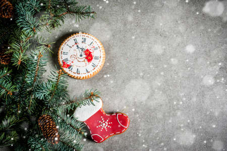 Christmas background with fir tree branch, homemade colorful gingerbread cookies, pine cones and decorations on grey stone table. Top view, copy spaceの写真素材