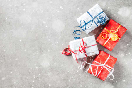 Christmas background with decorated gifts. Gray background, snow effect, Top view copy space