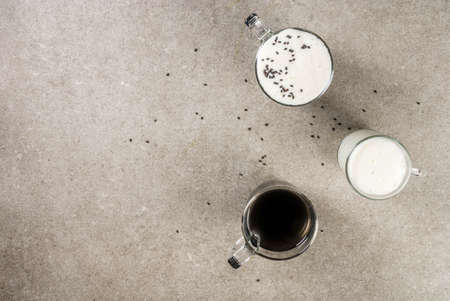 Trendy vegan food recipes, Black Sesame Cappuccino with sesame seeds and whipped coconut milk, grey stone table, copy space top viewの写真素材