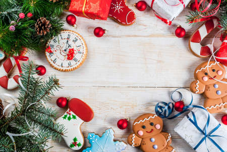 Festive Christmas wooden white background, with Christmas tree branches, pine cones, decorations, Christmas gifts and gingerbread, top view copy spaceの写真素材