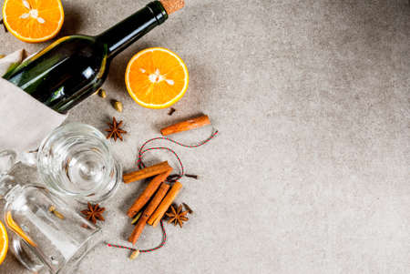  Christmas hot drinks recipes, Set of ingredients for mulled wine: wine bottle, glass cups, spices, orange. Gray stone background, copy space top viewの写真素材