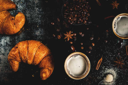 Homemade continental breakfast, coffee with spice, cane sugar, croissants. jam on a black rusty metal table, top view copy spaceの写真素材