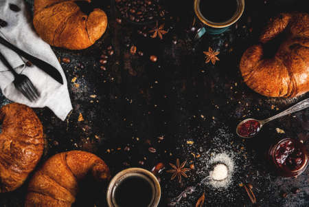 Homemade continental breakfast, coffee with spice, cane sugar, croissants. jam on a black rusty metal table, copy space top view frameの写真素材