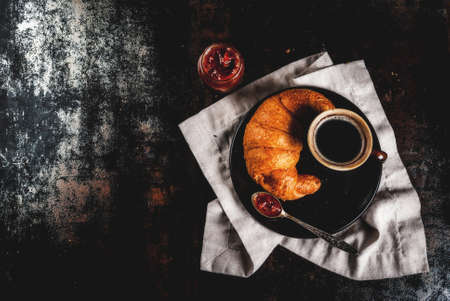 Homemade continental breakfast, coffee with spice, cane sugar, croissants. jam on a black rusty metal table, copy space top viewの写真素材