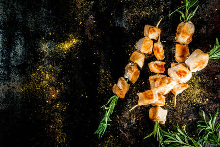 Grill, barbecue meat. Chicken skewers with rosemary. On a black rusty metallic background, copy space top viewの写真素材