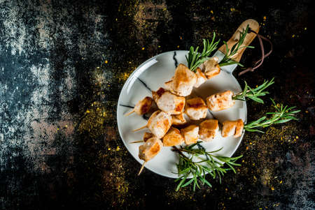 Grill, barbecue meat. Chicken skewers with rosemary. On a black rusty metallic background, copy space top viewの写真素材