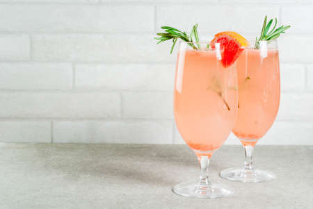 Festive drink for Christmas party, Mimosa cocktail with Champagne, Grapefruit and Rosemary, on stone tale, copy spaceの写真素材