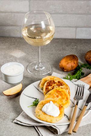 Vegan food. Cheese mashed potato pancakes, cutlets with dill and sour cream. On gray stone background, copy spaceの写真素材