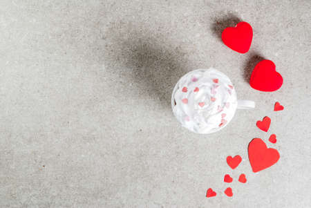 Romantic background, Valentine's day. Cup for coffee or hot chocolate, with whipped cream and sweet hearts, with two plush red hearts,  copy space top viewの写真素材