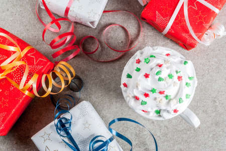 Christmas and New Year concept. Christmas gift boxes and cup for coffee or hot chocolate, with whipped cream and sweet stars decoration, on gray stone table, copy space top viewの写真素材