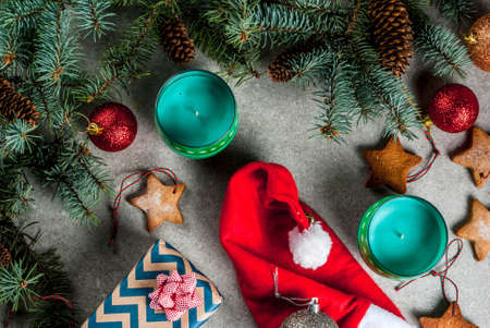 Christmas table, background for greeting card. Christmas decoration, candles, fir tree and gingerbread cookies on grey stone table. Top view, copy space.の写真素材