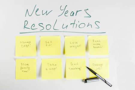 New years resolutions, white board background with colorful sticky notes with popular new year resolutions and pen, copy spaceの写真素材