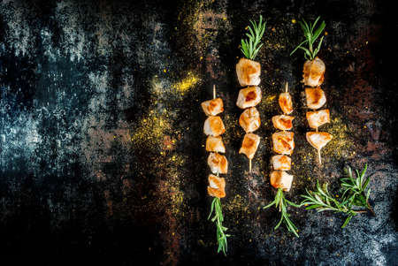 Grill, barbecue meat. Chicken skewers with rosemary. On a black rusty metallic background, copy space top viewの写真素材