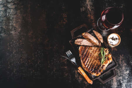 Grilled beef steak with spices on grill pan board, with and red wine glass. Copy space top viewの写真素材