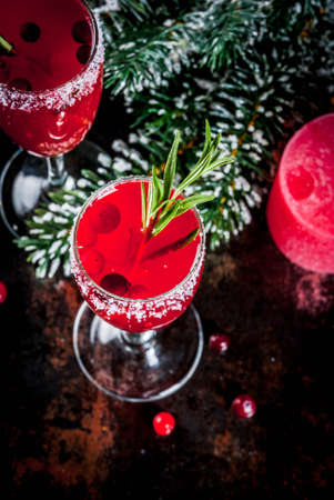 Christmas morning red cranberry mimosa with rosemary, dark background copy space with christmas decorations top viewの写真素材