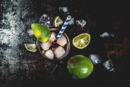 Cuba Libre, long island or iced tea cocktail with strong alcohol, cola, lime and ice, two glass, dark background copy space top viewの写真素材