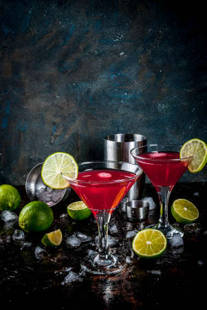 Red cosmopolitan cocktail with lime in martini glass, on dark rusty background copy spaceの写真素材