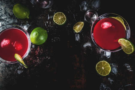 Red cosmopolitan cocktail with lime in martini glass, on dark rusty background copy space top viewの写真素材