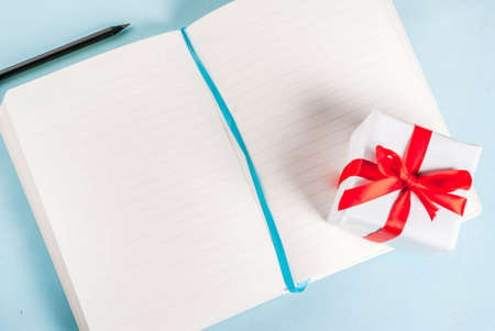 Valentine's day light blue background. Gift, notepad and pencil. Greeting card concept. Top view...