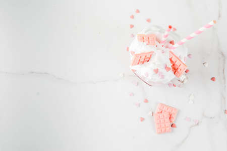 Crazy shake, romantic milkshake for Valentine's day with strawberry, white chocolate and sugar candy hearts, on white background, copy space top viewの写真素材
