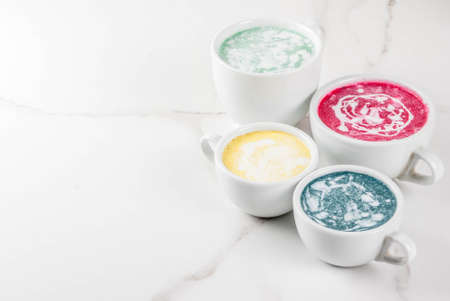 Organic vegan Latte coffee, decaffeinated - turmeric, beetroot, seaweed and matcha. On a white marble background, top view copy spaceの写真素材