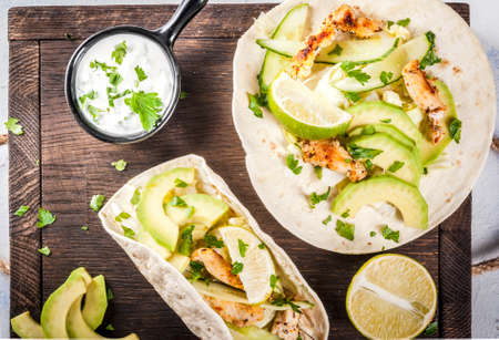 Healthy food snack. Tortillas taco with grilled chicken, avocado, fresh salsa, lettuce, lime. With...