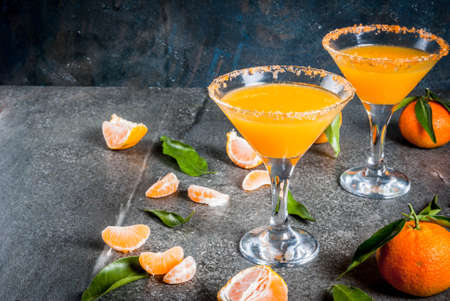 Recipes and ideas of winter fruit cocktails, Tangerine martini margarita with fresh tangerines, on dark background, copy spaceの写真素材