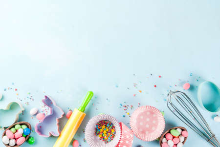 Sweet baking concept for Easter,  cooking background with baking - with a rolling pin, whisk for whipping, cookie cutters, sugar sprinkling, flour. Light blue background, top view copy spaceの写真素材