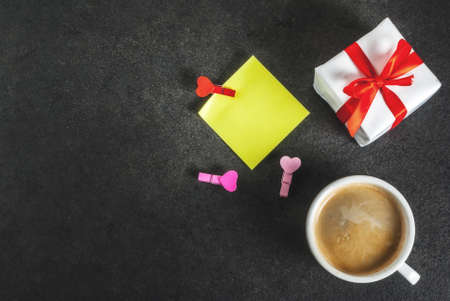 Valentine's day concept, gift box with red ribbon, coffee mug, blank paper note for congratulations...