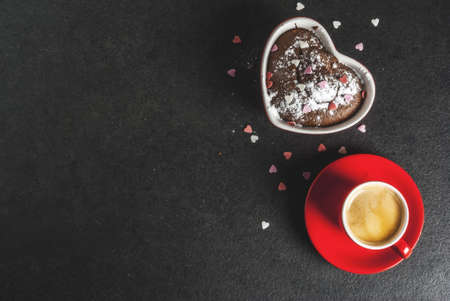 Valentine's day background, red coffee mug and chocolate mug cake or brownie with powdered sugar and sweet heart shaped sprinkles, black background, copy space top viewの写真素材