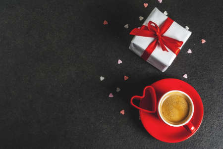 Valentine's day concept, gift box with red ribbon, coffee mug, black background, copy space  top viewの写真素材