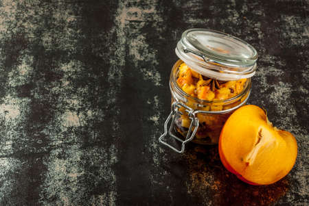 Traditional indian food recipes, Persimmon fruit Chutney with cinnamon and anise stars, dark rusty background copy spaceの写真素材