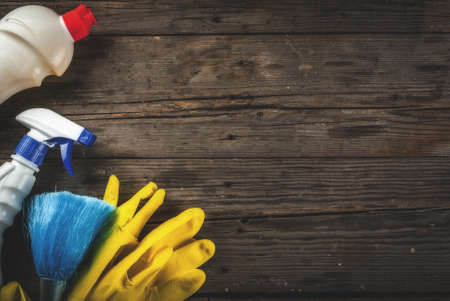 Spring cleaning concept with supplies, house cleaning products pile. Household chore concept, on rustic or garden wooden background copy space  top viewの写真素材