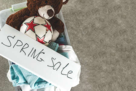 Plastic spring sale box with toys, clothes, white grey background copy space top viewの写真素材