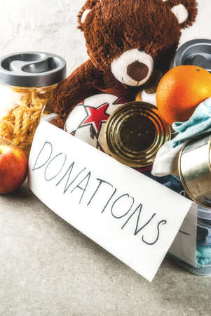 Plastic donation box with toys, clothes and food, white grey background copy spaceの写真素材