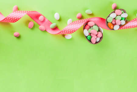 Easter holiday greeting card background, with chocolate easter bunny, candy eggs, quail eggs and...
